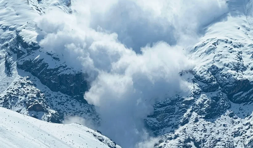 a massive avalanche of snow cascading down a snow-covered mountain