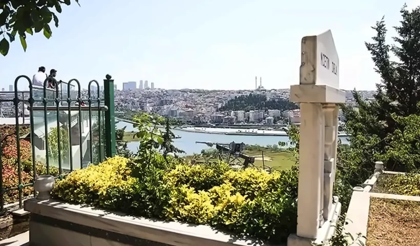 una tumba musulmana en un cementerio rodeado de vegetación con una vista sobre los edificios de Estambul al fondo