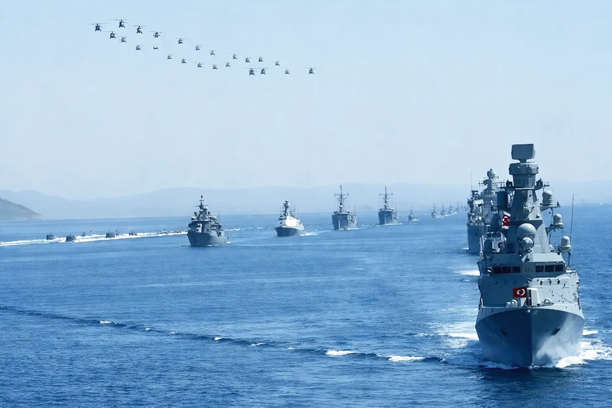 dozens of military vessels and aircraft flying over the sea during Turkish naval exercises