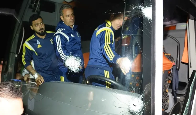 varios jugadores del Fenerbahçe se suben a un autobús en cuyo parabrisas delantero se observan varios impactos de bala