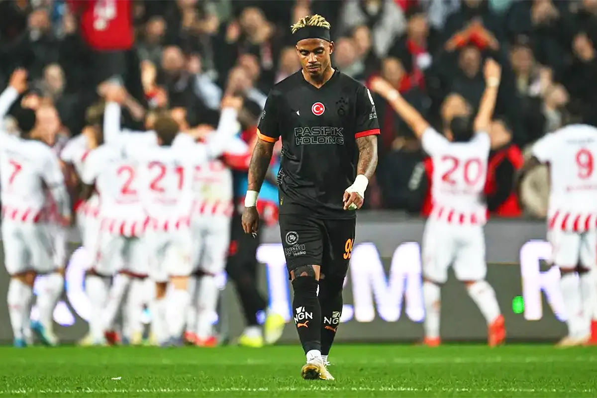 Samsunspor players celebrate a goal in the background; in the foreground, a dejected Galatasaray player walks away from the scene