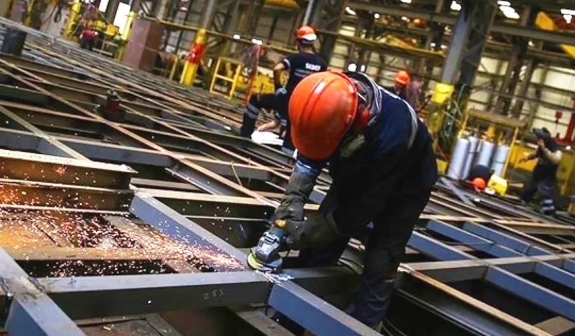 construction workers operating cutting machinery on a metal structure