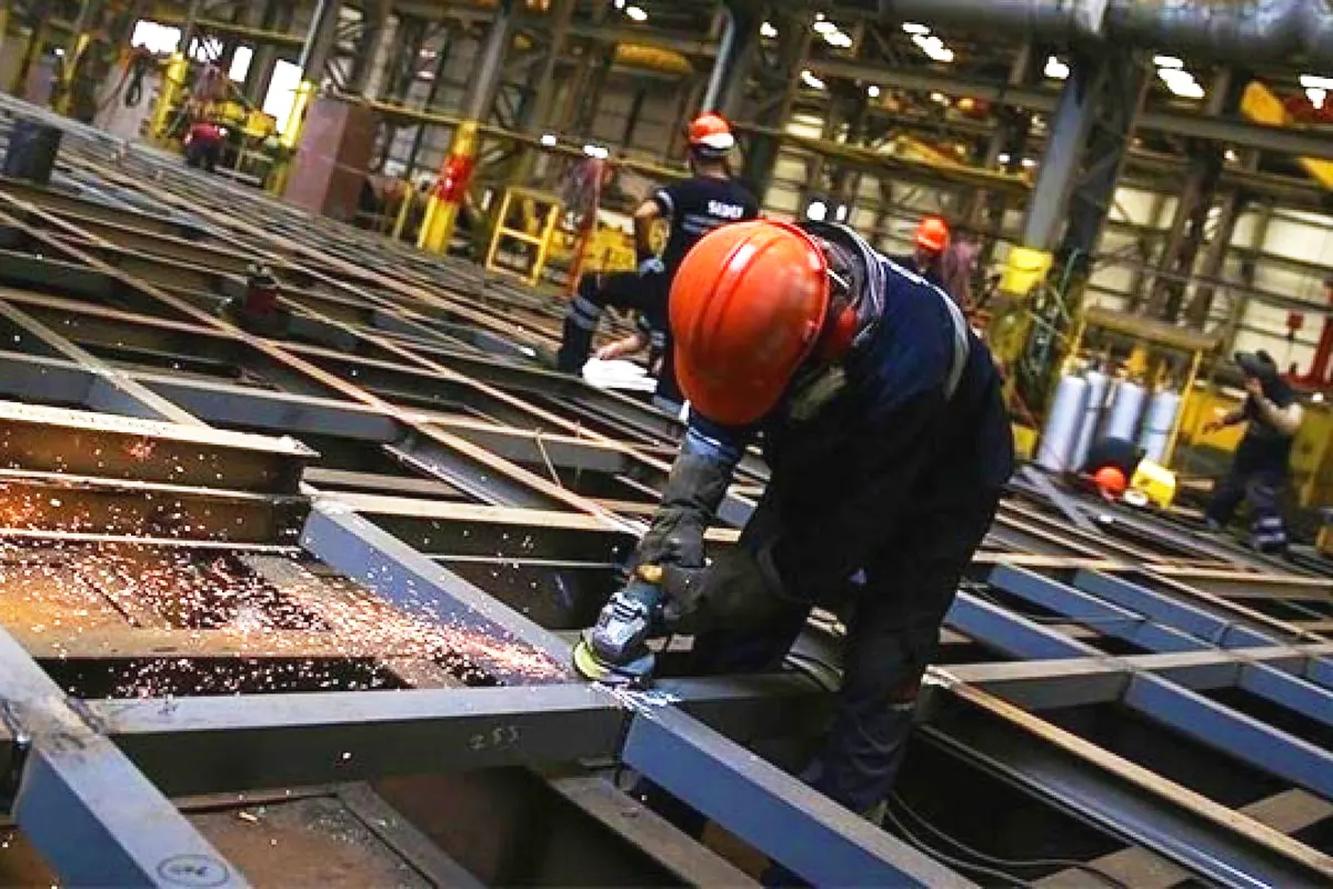 construction workers operating cutting machinery on a metal structure