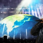 Kanye West on a giant globe during his concert in Istanbul; in the foreground, a photo of the artist