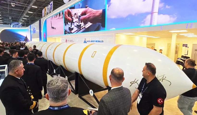 A huge ballistic missile, positioned horizontally, is on display at a crowded exhibition attended by members of the military.
