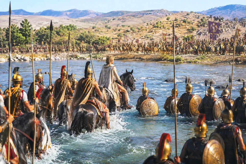 imagen que representa a Alejandro Magno cruzando con el ejército macedonio el río Gránico mientras al otro lado de la orilla se encuentra un gran ejército persa