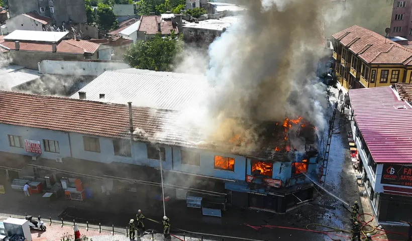 a huge column of smoke rising from a burning building in a bazaar