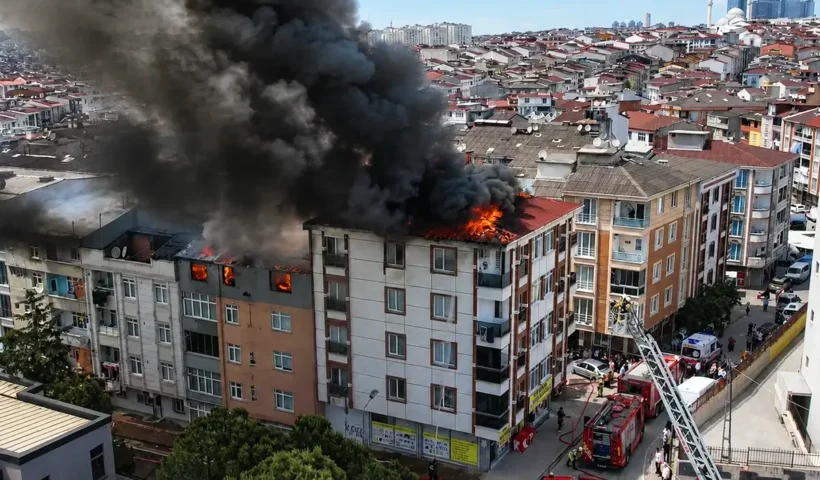 Flames and smoke billowing from several buildings in a residential block, with several fire engines in the vicinity