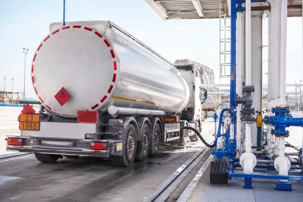 a tanker lorry being filled with fuel at a refinery