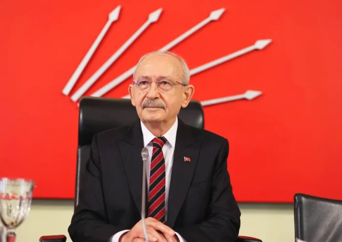 a picture of Kılıçdaroğlu sitting in his office with the CHP symbol in the background