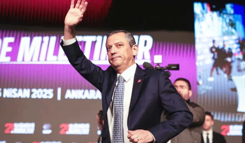 el político turco Özgür Özel saluda al público con gesto serio durante un evento público