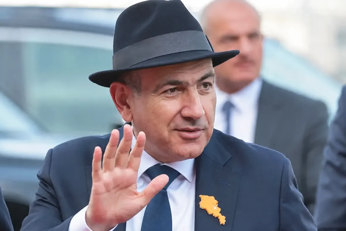 a picture of Armenian Prime Minister Nikol Pashinyan wearing a suit and hat