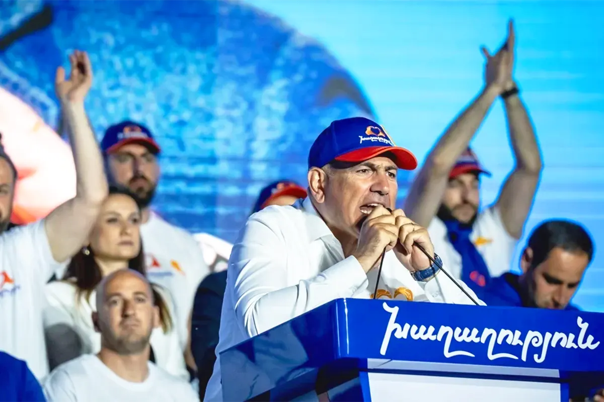 el primer ministro armenio Nikol Pashinyan habla desde un podio a seguidores de su partido durante la campaña electoral