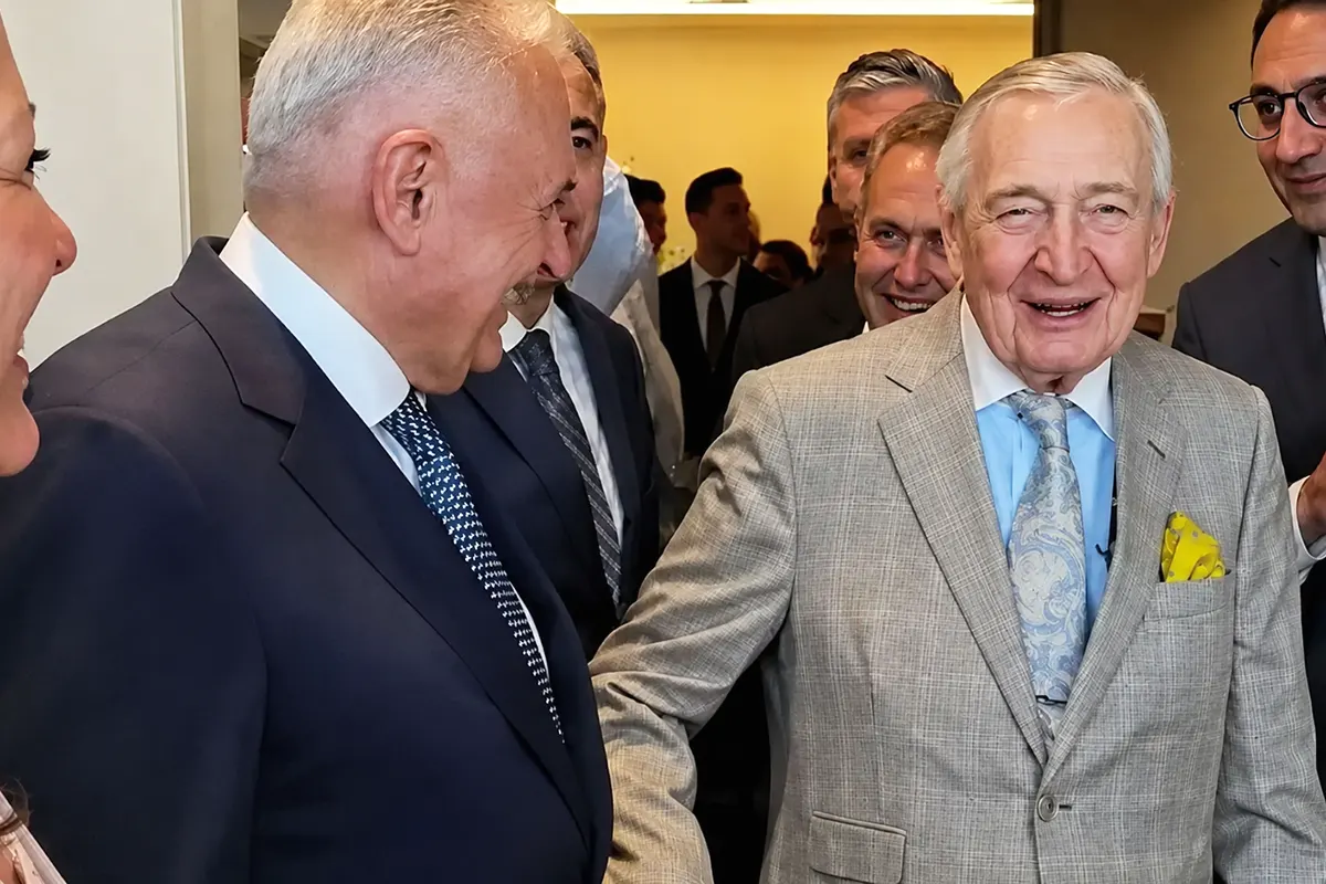 Turkish businessman Rahmi Koç is pictured with several people, including former Prime Minister Binali Yıldırım, as everyone present laughs