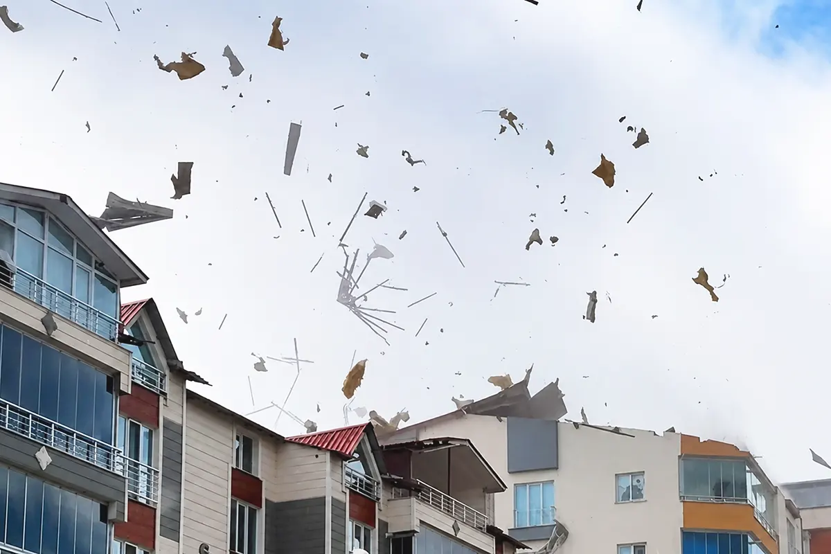 debris flying through the air near several residential buildings