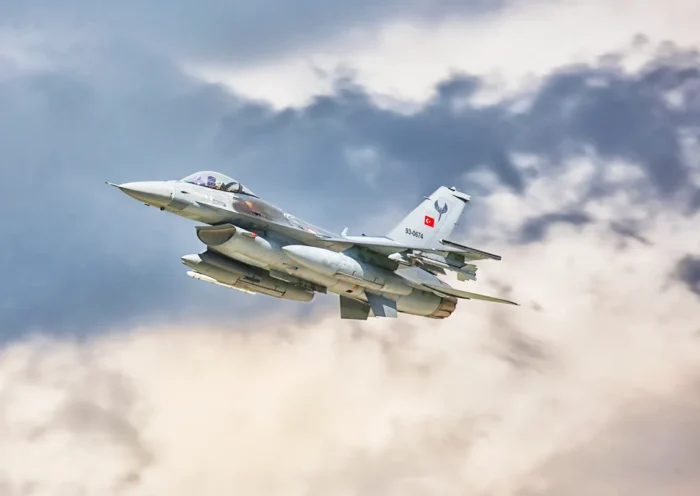 a Turkish F-16 fighter jet flying through the clouds