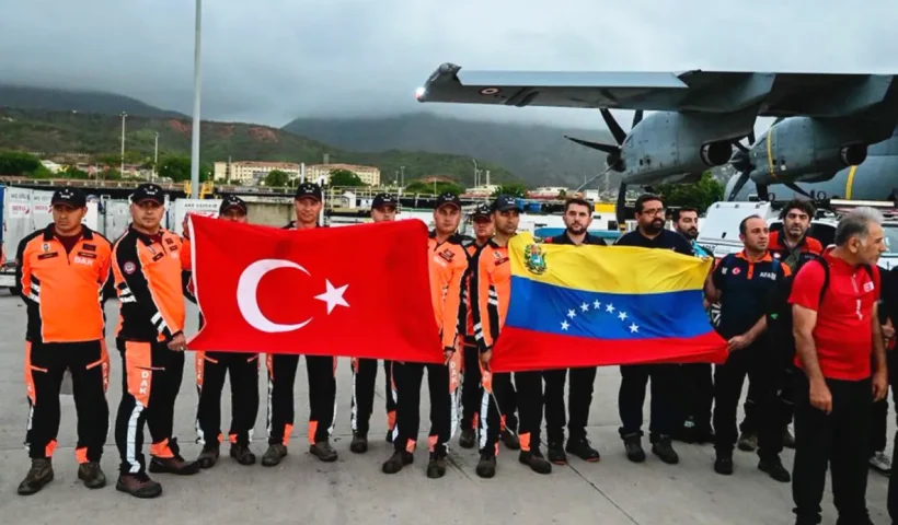 Turkish rescue teams standing next to the military aircraft in which they landed in Caracas, carrying the flags of Turkey and Venezuela