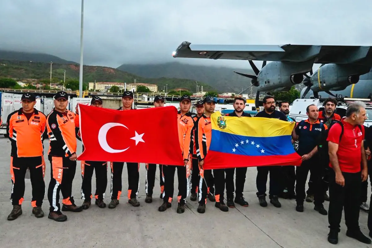 Turkish rescue teams standing next to the military aircraft in which they landed in Caracas, carrying the flags of Turkey and Venezuela