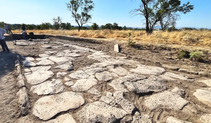 restos de una calle romana empedrada junto a un grupo de arqueólogos