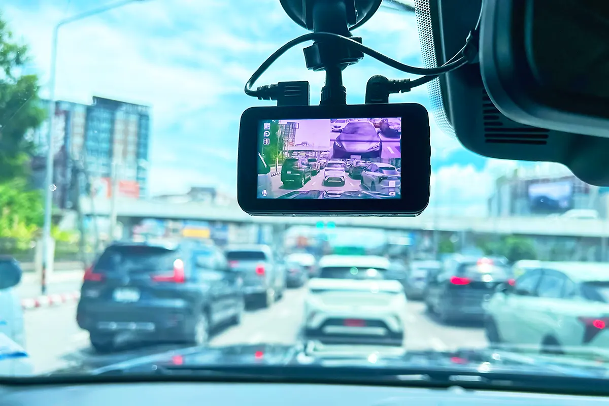 a dashcam on the dashboard of a car driving through traffic