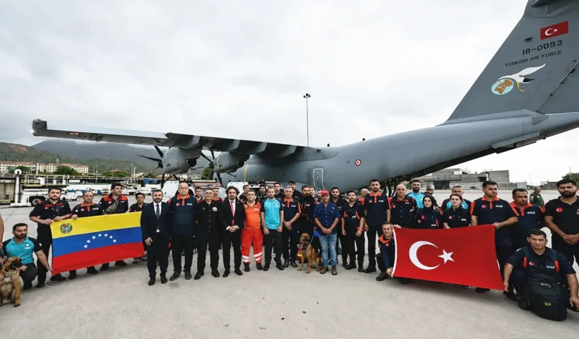 equipos de rescate enviados por Turquía tras el terremoto en Venezuela posan en el aeropuerto con las banderas de ambos países junto a un avión de las Fuerzas Aéreas Turcas