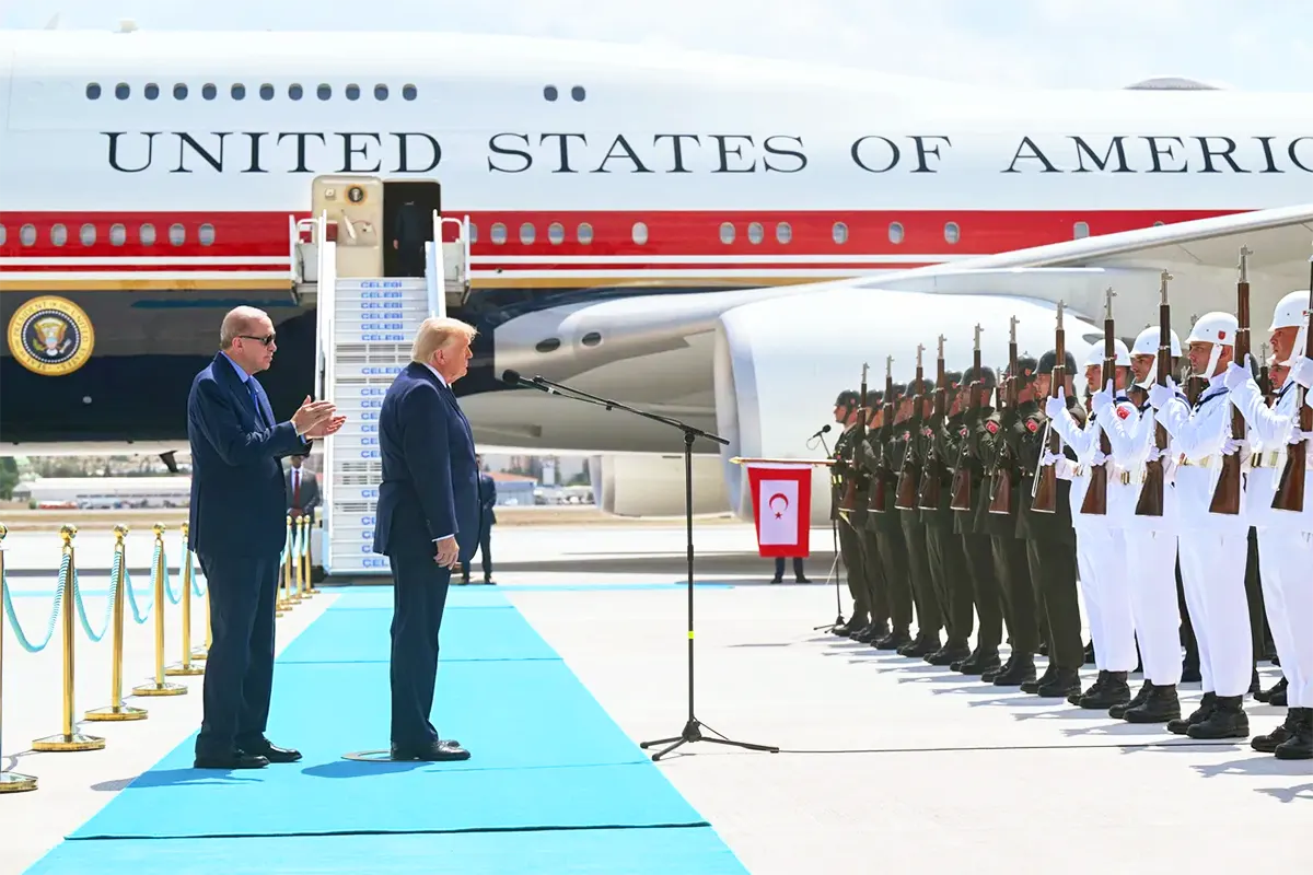 Erdoğan alongside Trump during a ceremony in front of Turkish soldiers; the US presidential aircraft, Air Force One, can be seen in the background