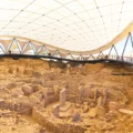 several stone pillars and stone circles at the Göbeklitepe sanctuary, viewed by tourists