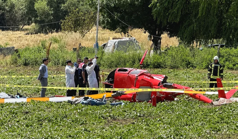 Forensic experts, military personnel and emergency services are surrounding the wreckage of a helicopter in a field