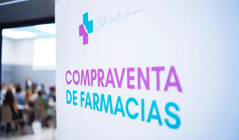 un cartel junto a un evento con público reza "compraventa de farmacias"