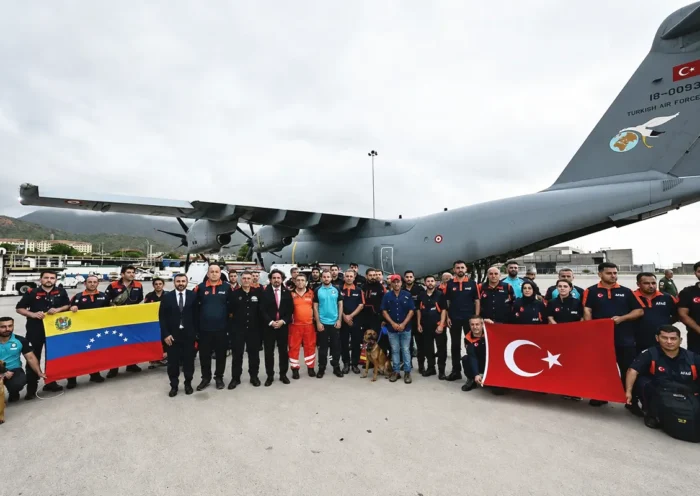 Rescue teams sent by Turkey following the earthquake in Venezuela pose at the airport with the flags of both countries next to a Turkish Air Force aircraft