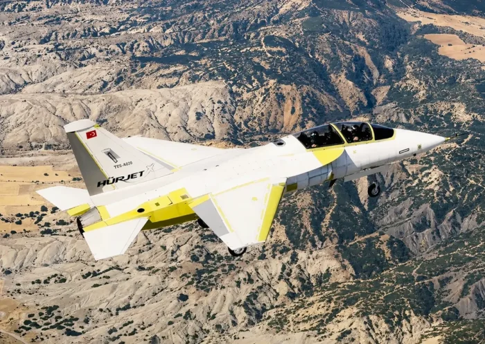 un prototipo de caza turco Hürjet con colores claros sobrevolando un paisaje del interior de Anatolia