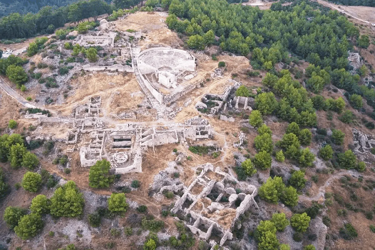 aerial view of some Roman ruins on a mountain surrounded by woods