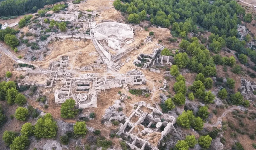 imagen aérea de unas ruinas romanas sobre una montaña rodeada de bosques