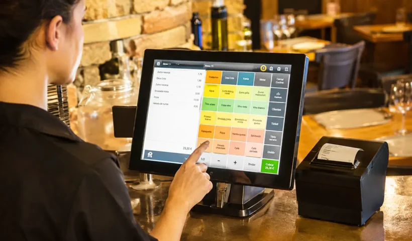 una camarera manejando en una pantalla de un restaurante un software TPV de gestión de pedidos