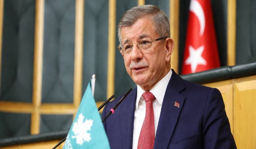 el ex primer ministro turco Ahmet Davutoğlu, hablando en público desde la sede del parlamento junto a una bandera de Turquía y de su Partido del Futuro