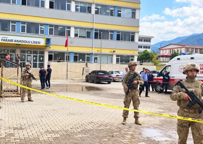 varios gendarmes turcos armados junto a una ambulancia a la entrada de un instituto
