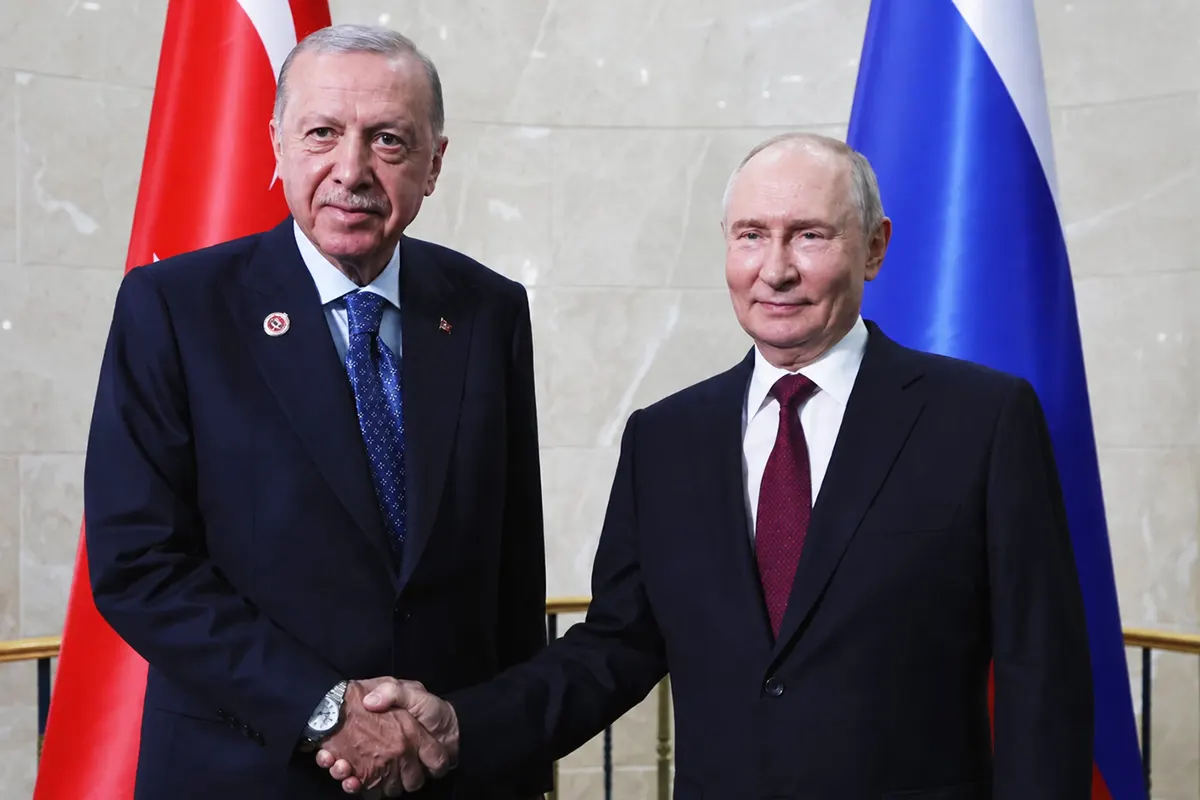 Erdoğan y Putin sonríen y se dan la mano posando para los fotógrafos con las banderas de Turquía y Rusia de fondo