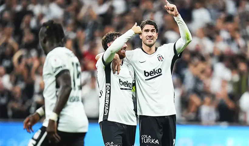dos jugadores del Beşiktaş se abrazan y señalan al cielo tras marcar un gol