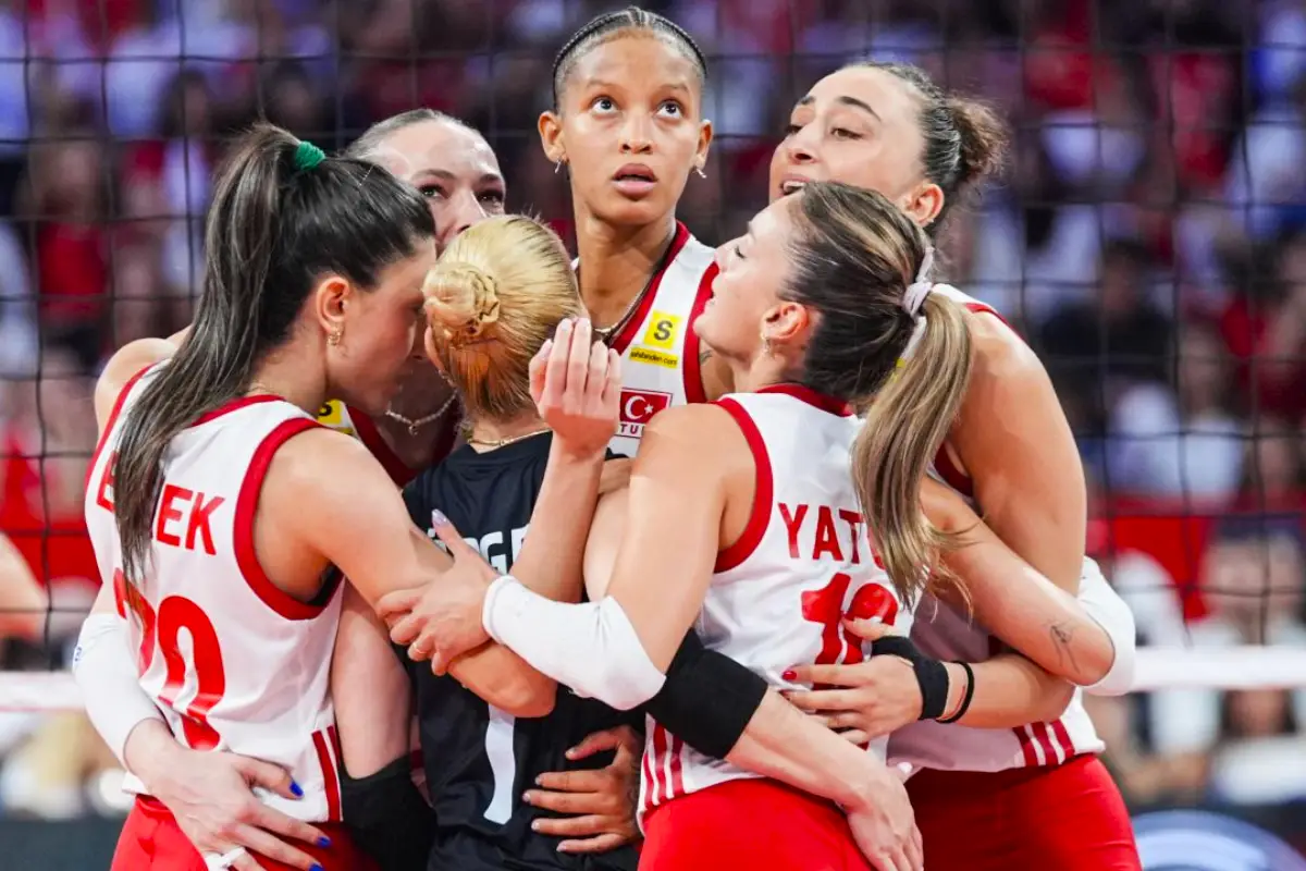 Players from the Turkish women’s volleyball team embrace on the court