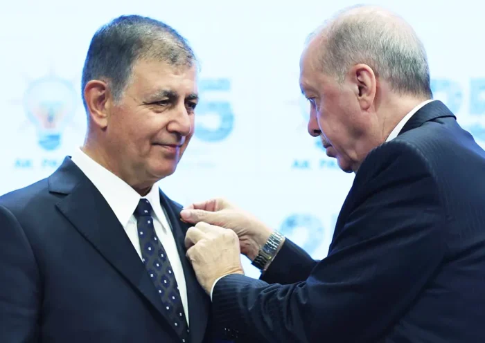 Erdoğan colocando una insignia de su partido AKP en la solapa del alcalde de Izmir, Cemil Tugay