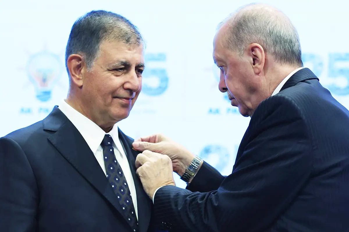 Erdoğan colocando una insignia de su partido AKP en la solapa del alcalde de Izmir, Cemil Tugay