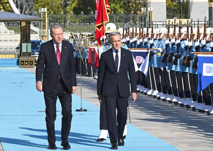 Erdoğan y Carney caminan junto a varios soldados durante una ceremonia oficial en el palacio presidencial de Ankara