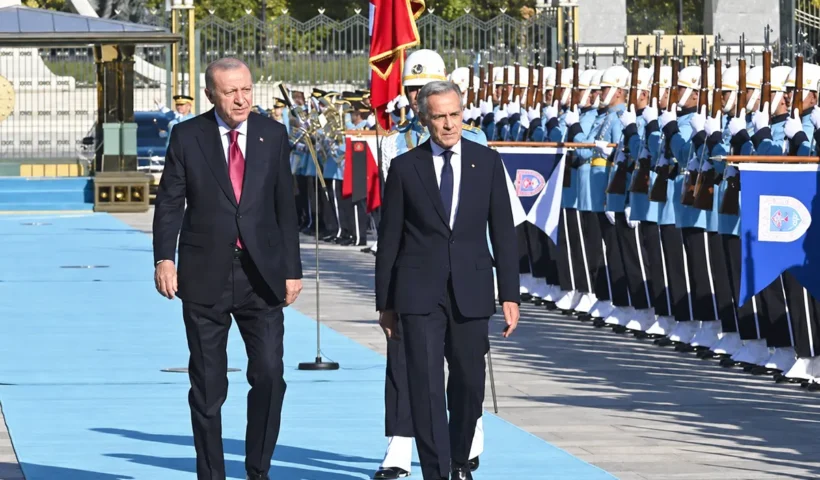 Erdoğan y Carney caminan junto a varios soldados durante una ceremonia oficial en el palacio presidencial de Ankara