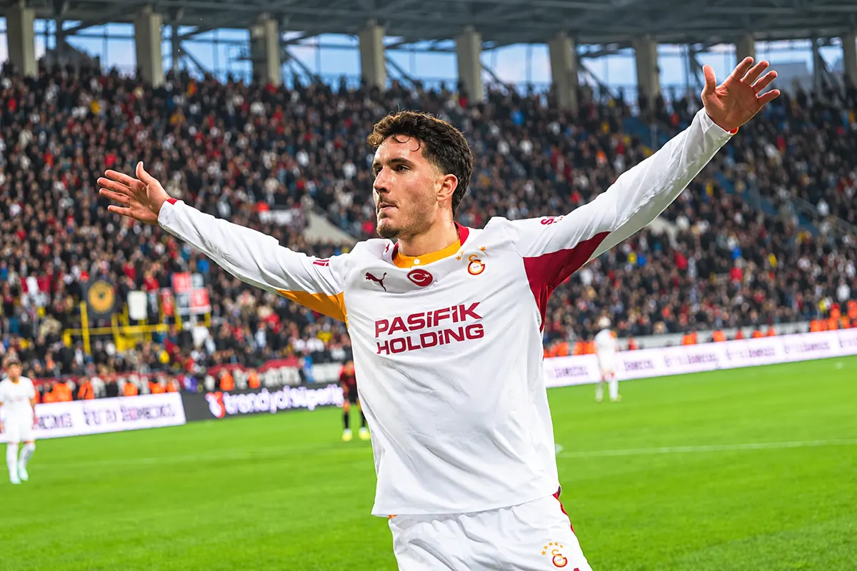 Deniz Gül celebrates a goal with his arms outstretched in a stadium whilst wearing the Galatasaray shirt