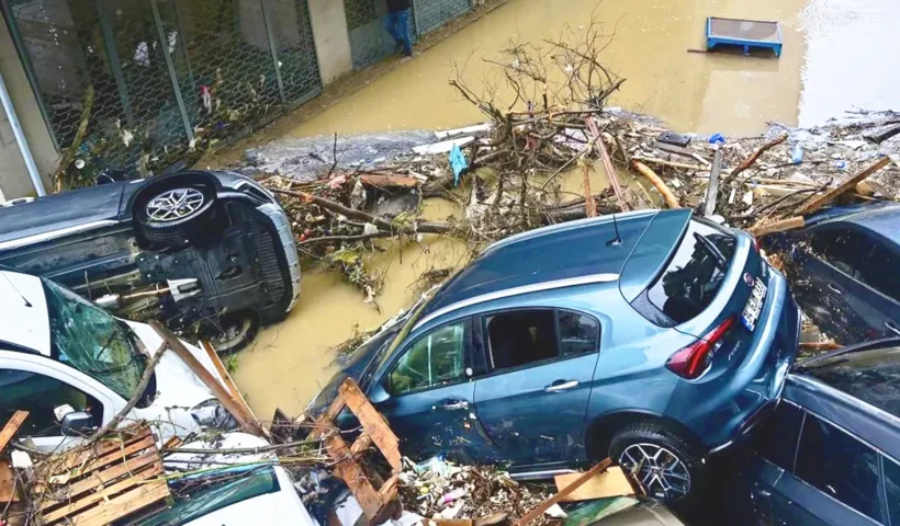 varios coches amontonados en una calle inundada junto a escombros y restos arrastrados por una riada