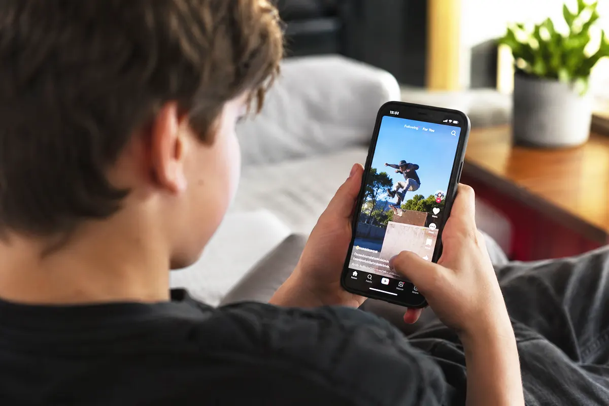 a child sitting with their back to the camera, watching a video on social media