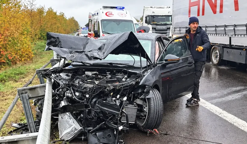 a car that has been completely wrecked, lying by the side of the road whilst being towed